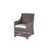 Woven wicker dining arm chair with white cushion in hickory finish.