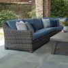 Outdoor wicker sectional with blue cushions featuring the right arm loveseat section and accent pillows.