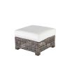 Woven wicker ottoman with white cushion in hickory finish.