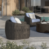 Pair of Boulevard wicker club chairs with cushions beside a round coffee table near pool.