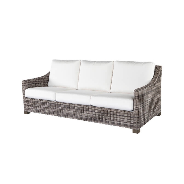 Woven wicker three-seat sofa with white cushions in hickory finish.