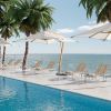 Poolside resort deck with Cabana woven chaise lounges in barley finish and umbrellas overlooking the ocean