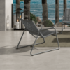 Woven club chair in fog gray finish with graphite frame on oceanfront patio
