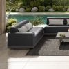 Grande wicker armless loveseat sectional in Coal Smoke with light cushions beside poolside lounge.