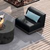 Grande wicker padded armless club chair in Coal Smoke set on patio with fire pit and accent pillow.