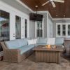Laurent wicker sectional sofa with light blue cushions and fire pit table on a covered patio.