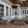 Laurent wicker sectional sofa with armless chair and light blue cushions around a fire pit table on a patio.