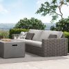 Mia Woven Cushion XL Sofa in Fog Finish with Gray Cushions displayed beside a modern concrete fire pit
