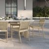 Orleans woven dining arm chairs in Barley Flax finish around an outdoor dining table.