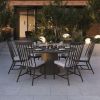 Outdoor dining scene with Palazzo cushion dining side chairs in Cocoa finish around a round dining table.