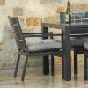 Close-up of Palermo cushion dining arm chair paired with outdoor dining table and wine glasses