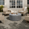 Outdoor gathering space featuring a gray Bellino round fire pit table and wicker chairs