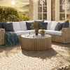 Hampton 42" round chat table with concrete-style top and wicker sectional sofa on patio