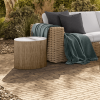 Hampton round patio side table with alabaster top beside wicker sectional seating in outdoor lounge