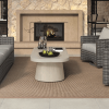Pompano patio coffee table in shell finish styled in outdoor living room with stone fireplace