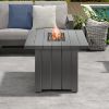 Modern gray Trevi fire pit patio table with flames, set on a poolside outdoor lounge.