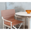 Boss folding sling dining chair with amber fabric paired with a round café table in a modern dining setting