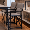 Boss folding sling dining chairs with gray fabric and black frames arranged around a commercial dining table