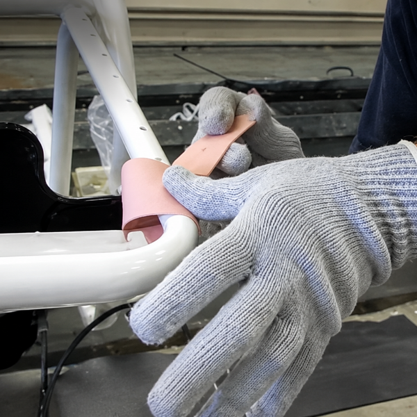 Worker installing new vinyl straps on a commercial pool furniture frame