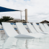 White Forma in-pool chaise lounges arranged on a shallow swimming pool tanning ledge