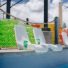 White Forma pool edge seat chairs installed along the edge of a commercial swimming pool
