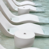 Multiple Forma in-pool side tables positioned between commercial in-pool chaise lounges