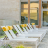 Row of Urban stackable aluminum sling chaise lounges arranged around a commercial outdoor pool area