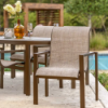 Urban stackable aluminum sling patio dining chairs arranged around an outdoor dining table beside a commercial pool