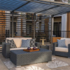 Highland Gray wicker outdoor patio lounge chair with cushions in a covered commercial outdoor seating area