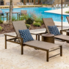 Urban aluminum sling chaise lounges with arms arranged beside a commercial resort swimming pool