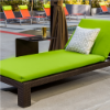 Java Chocolate wicker cushioned chaise lounge with bright green fabric positioned beside a commercial swimming pool