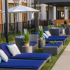 Highland Gray wicker chaise lounges with blue cushions arranged in a commercial poolside seating area