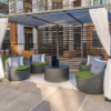 Highland Gray wicker commercial patio barrel chairs with green cushions arranged beneath an outdoor cabana