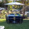 42" x 60" MGP rectangular patio dining table with six chairs and umbrella in a commercial outdoor dining area