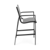 Side view of Metro sling commercial patio bar chair with Starlight Black aluminum frame, Metallica Platinum sling, armrests, and footrest