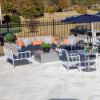Sonoma commercial patio dining chairs arranged with cushioned lounge seating, tables, and umbrella in an outdoor commercial patio setting